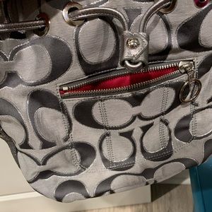 Grey metallic coach bucket purse.